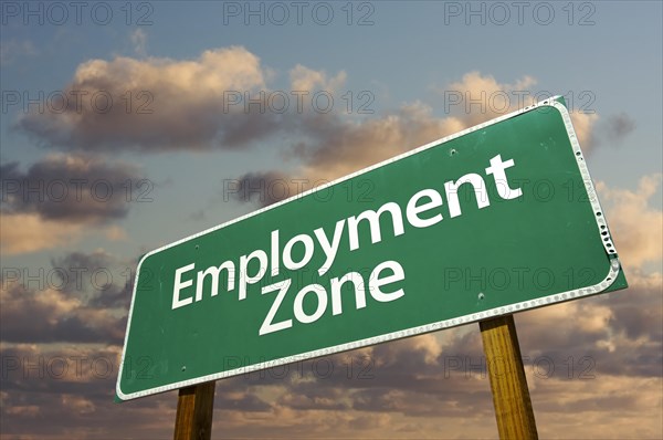 Employment zone green road sign in front of dramatic clouds and sky