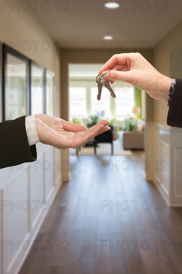 Woman handing over the keys inside hallway of new house