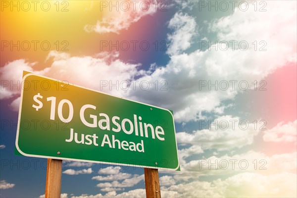 $10 gas green road sign against cloudy sky
