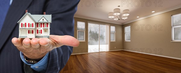 Real estate agent holding model home in new room of house