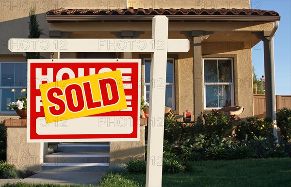 Sold home for sale sign in front of beautiful new house