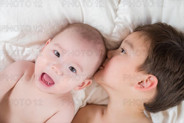 Young mixed-race chinese and caucasian baby brothers having fun on their blanket