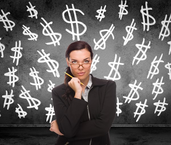 Dollar signs drawn on wall behind young adult woman with pencil