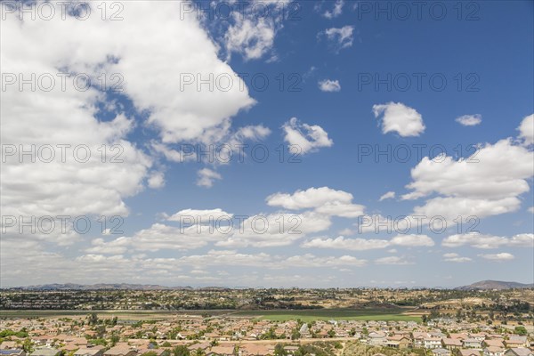 Elevated view of new contemporary suburban neighborhood and majestic clouds