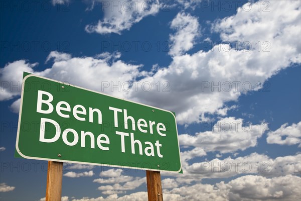 Been there done that green road sign with dramatic sky and clouds