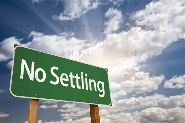 No settling green road sign with dramatic clouds