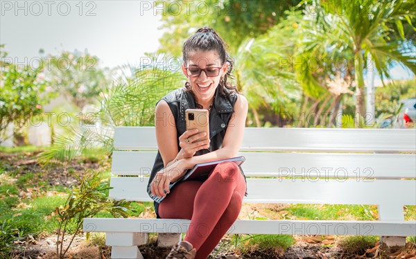 Girl sitting on a bench checking her cell phone