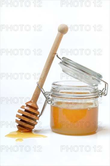 Bienenhonig in Glas und Honigloeffel