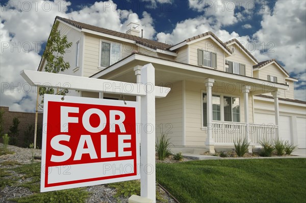 Home for sale sign in front of beautiful new home