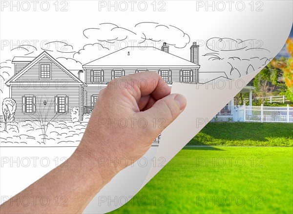 Male hand turning page of custom home photograph to drawing underneath