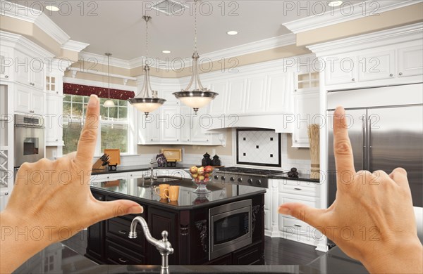 Female hands framing A beautiful custom kitchen interior