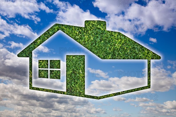 Green grass house icon over blue sky and clouds