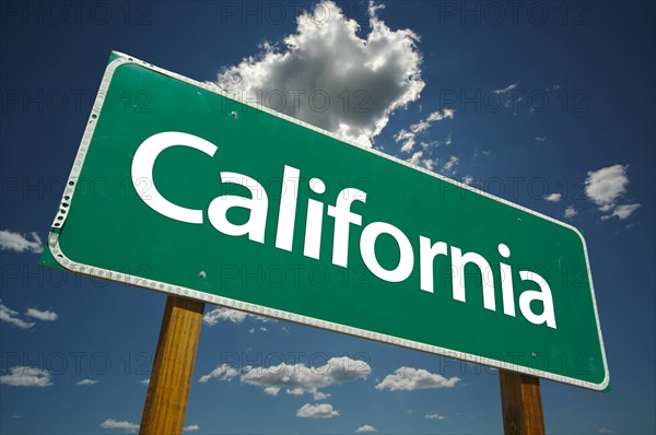 Green california road sign with dramatic clouds and sky