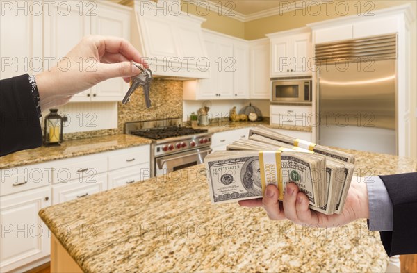 Handing over keys for cash in beautiful custom kitchen interior