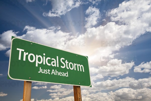 Tropical storm green road sign with dramatic clouds and sky