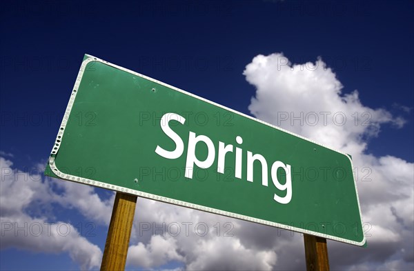 Spring road sign with dramatic clouds and sky