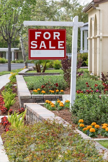 Home for sale real estate sign in front of new house