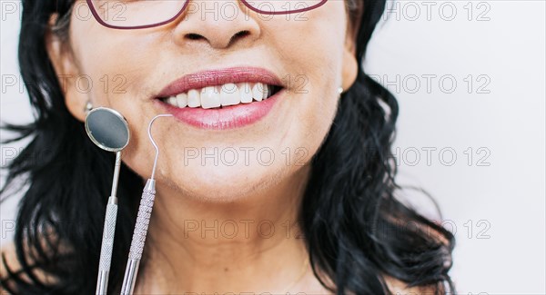 Close up of perfect smile and dentist tools on white background