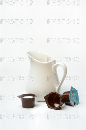 A milk can and milk in portion pack