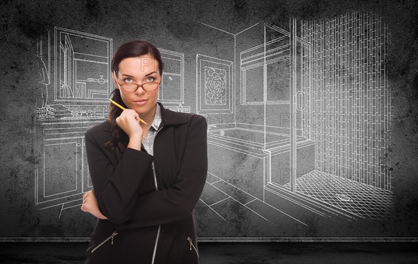 Young adult woman with pencil in front of bathroom design drawing on wall