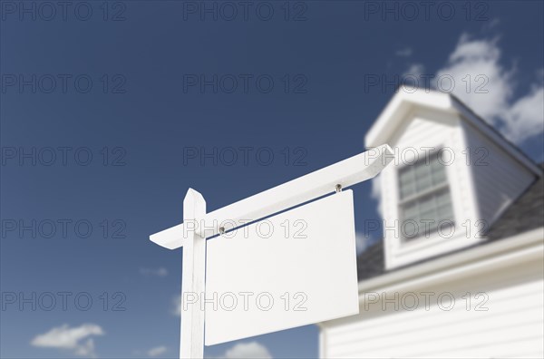 Blank real estate sign in front of beautiful new house