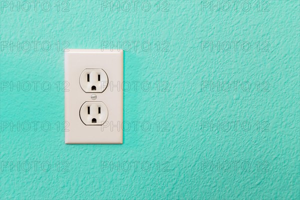 Electrical sockets in colorful bright teal wall of house