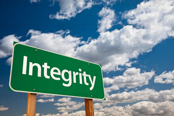 Integrity green road sign with copy room over the dramatic clouds and sky