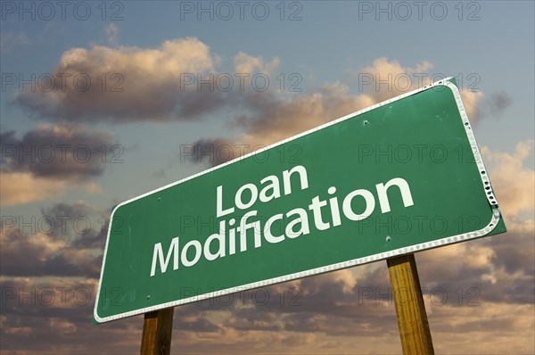 Loan modification green road sign with dramatic clouds and sky