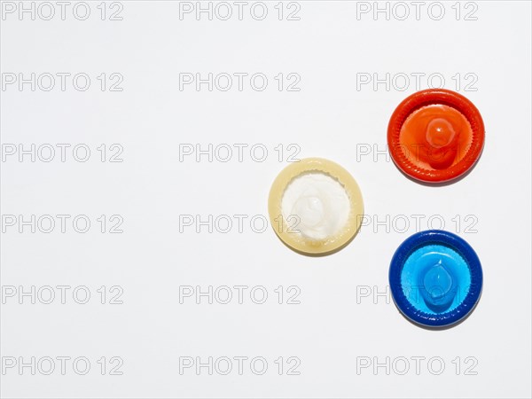 Above view unwrapped condoms on white background