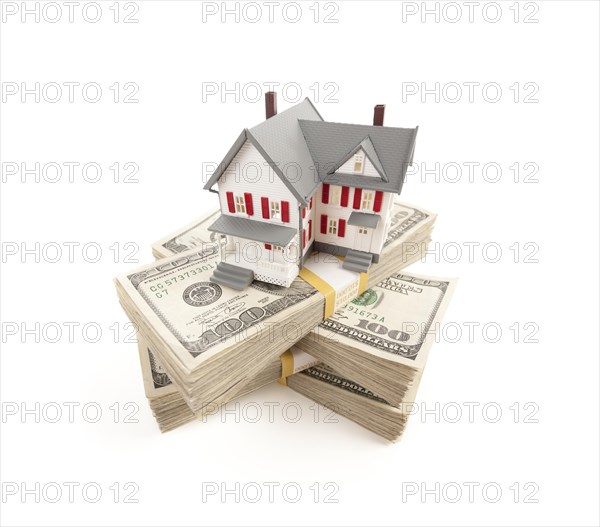 Small house on stacks of hundred dollar bills isolated on a white background