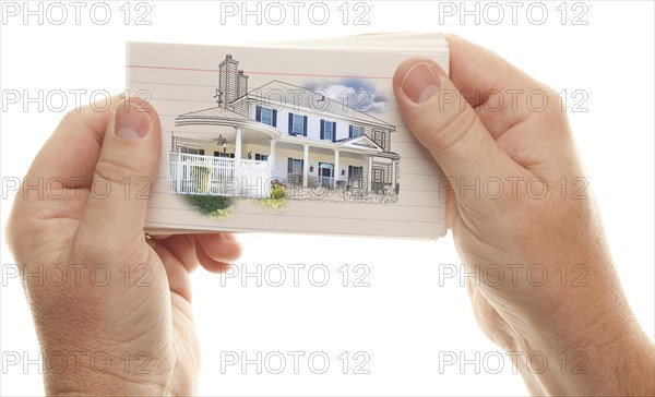 Male hand holding stack of flash cards with house drawing isolated on a white background