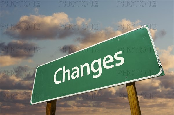 Changes green road sign with dramatic blue sky and clouds