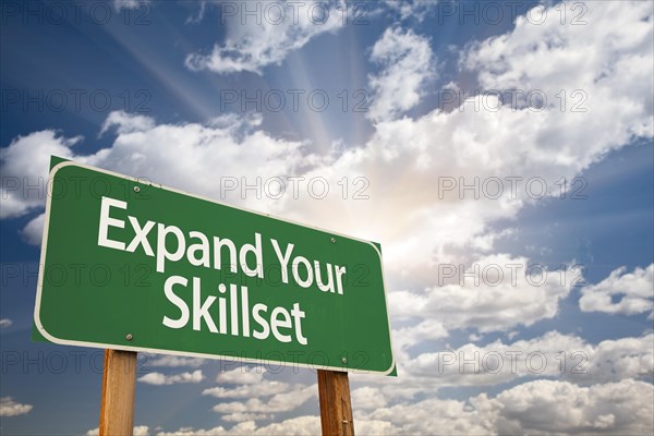 Expand your skillset green road sign with dramatic clouds and sky