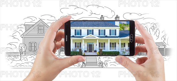 Hands holding smart phone displaying custom home photo of drawing behind