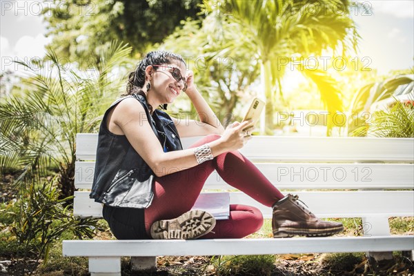 Girl sitting on a bench checking her cell phone