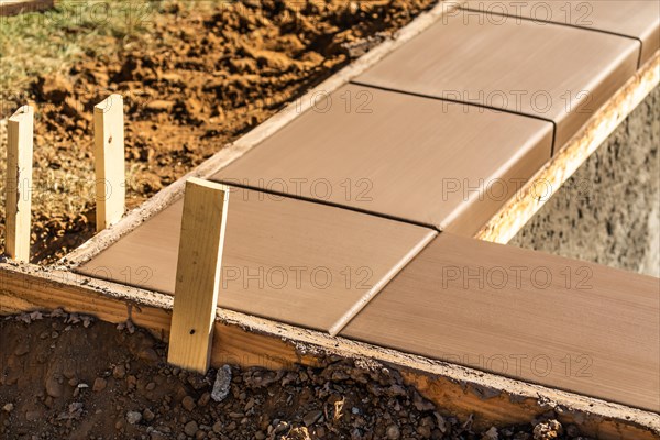 Fresh pool coping cement drying within wood framing