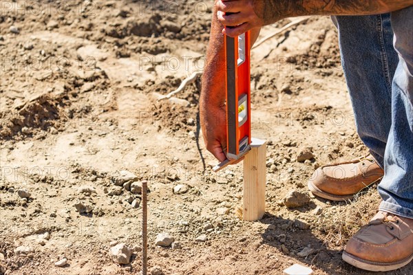 Worker using level at construction site