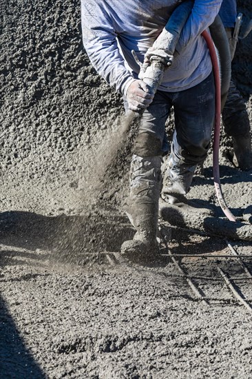 Pool construction worker shooting concrete