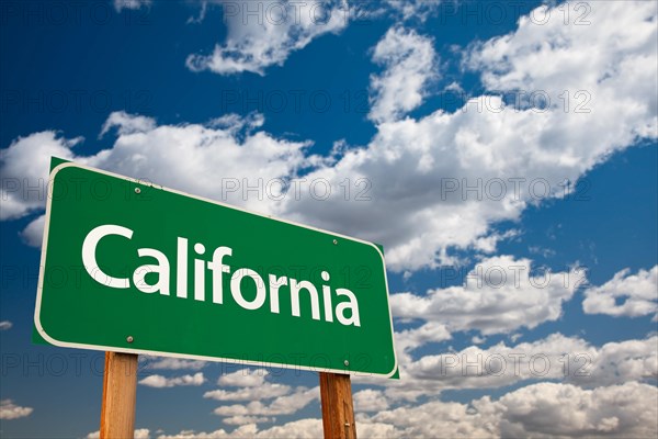 California green road sign with copy room over the dramatic clouds and sky