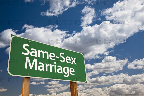 Same-Sex marriage green road sign over dramatic blue sky and clouds