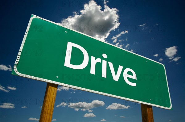 Drive green road sign with dramatic clouds and sky