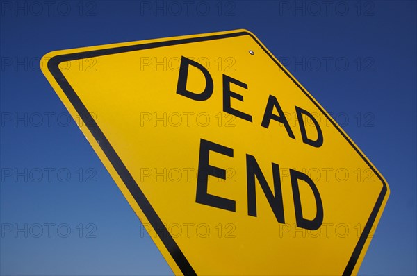 Dead end traffic sign against deep blue sky