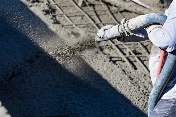 Pool construction worker shooting concrete