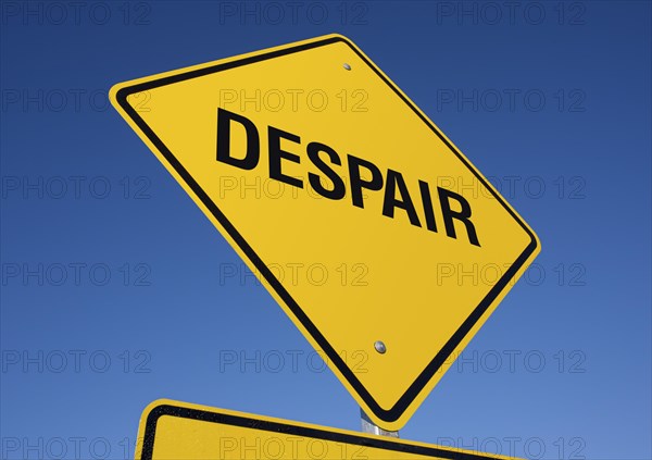 Despair yellow road sign against a deep blue sky with clipping path