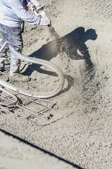 Pool construction worker shooting concrete