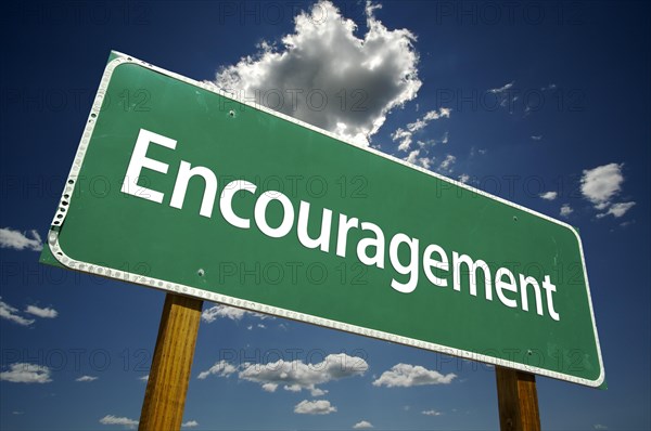 Encouragement road sign with dramatic clouds and sky