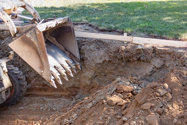 Small bulldozer digging in yard for pool installation