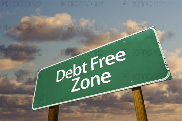 Debt free zone green road sign in front of dramatic clouds and sky