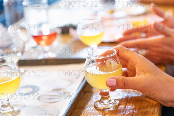 Female hand holding glass of micro brew beer at bar