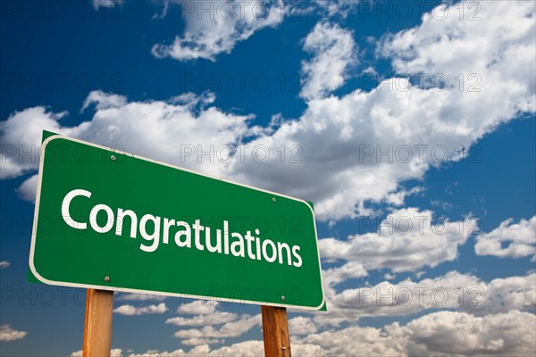 Congratulations green road sign with dramatic clouds and sky